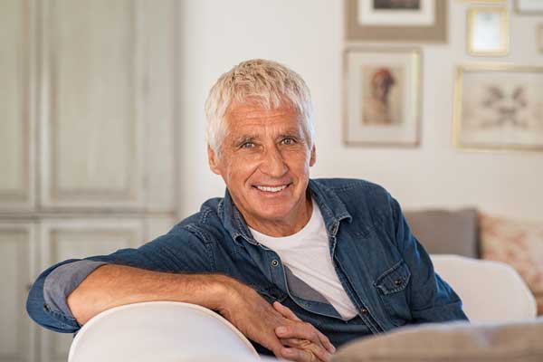 Smiling senior man sitting on couch